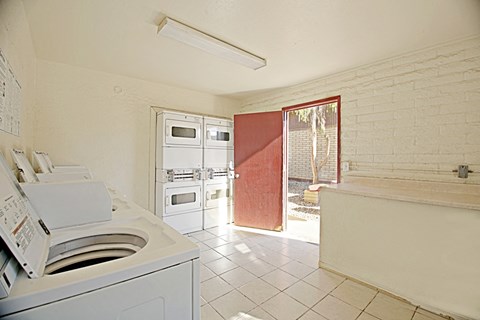 a laundry room with a washer and dryer and a door to a kitchen